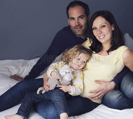 Parents and young daughter sitting together  portrait