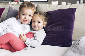 Young siblings sitting together on sofa  portrait