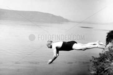 Mann springt in Wasser