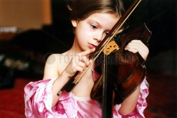 Maedchen in Kleid spielt Geige