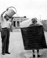 Mann giesst Wasser Frau Schutz 1940er