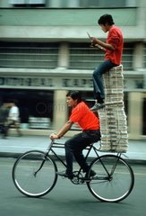 Zwei Personen & Zeitungen auf Fahrrad