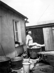Mann auf Badewanne im Freien 1920