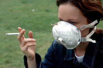 rauchende Frau traegt Munschutz