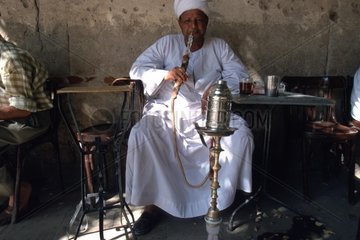 Mann raucht Wasserpfeife im Kaffeehaus
