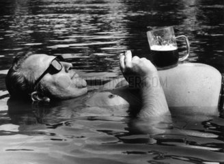 Mann trinkt Bier im Wasser