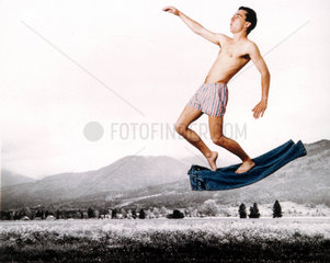 Mann steht auf fliegenden Jeans