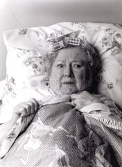 Oma mit Lockenwicklern im Bett