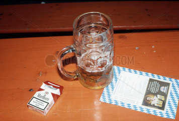 Bierglas und Zigaretten auf Tisch