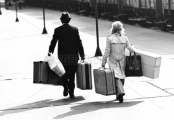 Paar transportiert Koffer