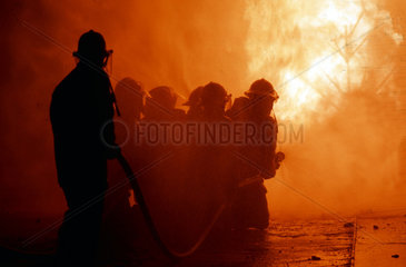 Feuerwehrmann loescht heftigen Brand