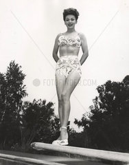 Frau in Bikini posiert auf Sprungbrett