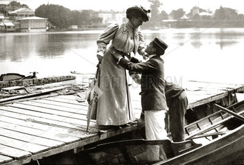 Mann hilft Frau ins Boot