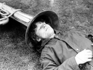 Mann schlaeft mit Kopf in Tuba