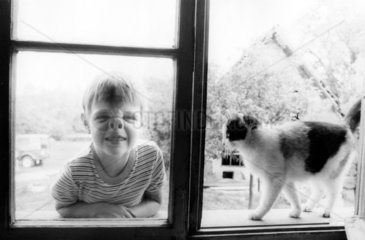 Kind und Katze am Fenster