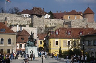 Fussgaenger in Stadtzentrum mit Stadtmauer