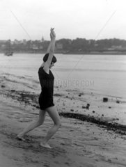 Frau macht Gymnastik am Strand  1920