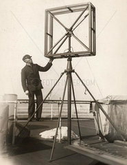 Mann steht neben viereckiger Antenne