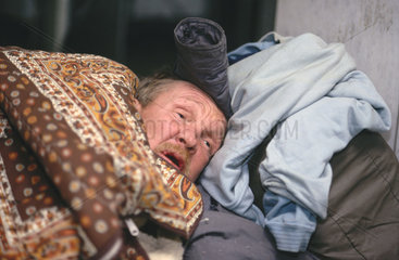 Obdachlose versuchen  bei -12Â°C in Geschaeftseingang zu schlafen