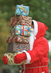 Weihnachtsmann mit Stapel von Geschenken