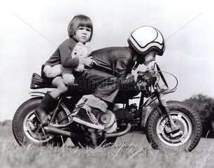 Junge und Maedchen fahren Motorrad
