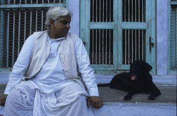 Hund liegt neben einem Mann Uttar Pradesh Indien