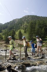 Family crossing Aigue Agnelle Queyras Alps France