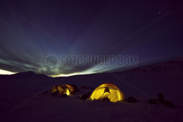 Lit tents at night - Agardbukta Spitzberg