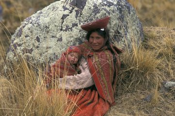 Frau in traditioneller Kleidung sitzt mit ihrem Kind Peru