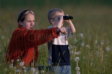 Frau und kleiner Junge  der mit Ferngläser Natur beobachtet
