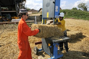 Cutting hay bales for wood-frame house France