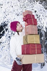 Small girl with Christmas presents in the snow