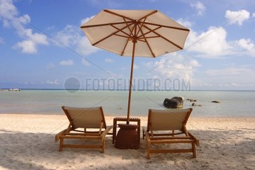 Armchairs and parasol on sand beach Thailand