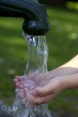 Water of a fountain flowing out in a child's hands
