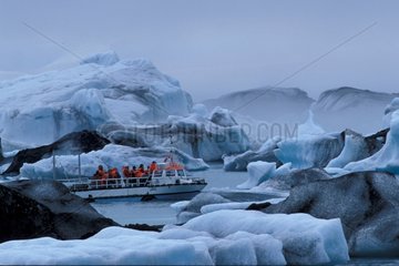 Touristenboot mitten in Eisbergen in einer Lagune