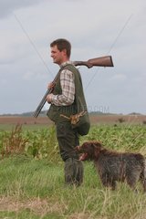 Hunter with a killed hare in a plain in autumn France