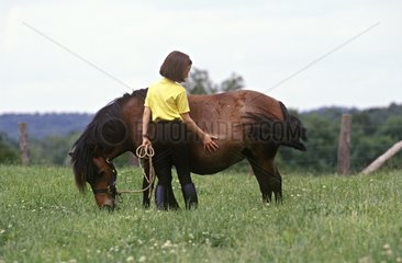 Girl caressing her pony
