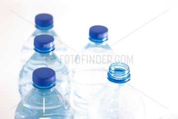 Six bottles of water including five with a blue cap
