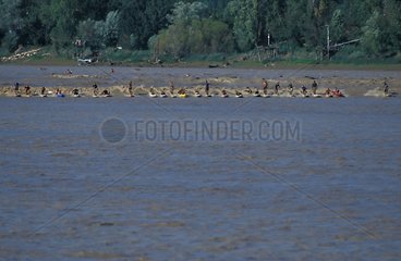 Surfers and kayakers on the tidal bore Gironde France