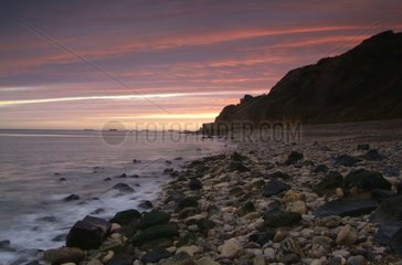 Pebble beach and Cliff at sunrise Calvados