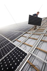 Installing solar panels on the roof of a farm building