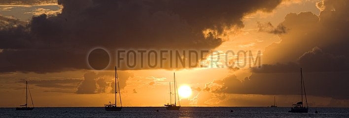 Sunset on the ocean and sailboats in Martinique Island