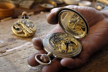 Alte Uhr in der Hand eines Uhrmachers hohe Zweifel