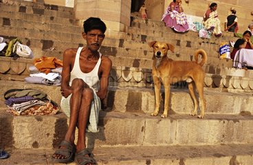 Mann und Hund auf Ghats neben dem Ganges Indien