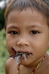 Mentawai child eating a dragonfly Siberut Sumatra