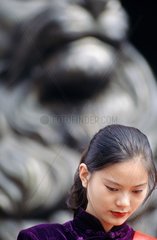 jeune femme devant une statue de lion