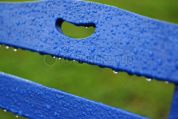 Water drops on the back of a wooden chair aften the rain