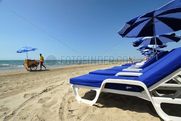 Selling near parasols and deck chairs on the beach