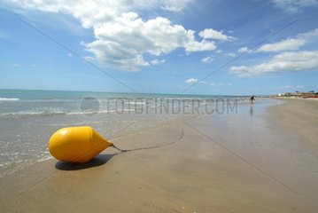 Yellow buoy grounding on a beach Hérault France