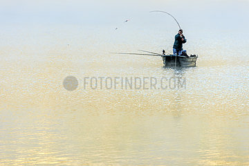 Fisherman in the morning mist on Lake Annecy in autumn  Haute Savoie  Alps  France